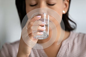 Hand of woman holding transparent glass of pure water