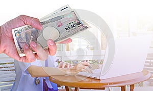 hand woman with Japanese currency yen bank notes on blurred back