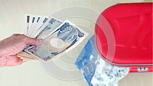 hand woman with Japanese currency yen bank notes on blurred back