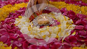 Hand of a woman lighting up a beautiful oil lamp placed in the center