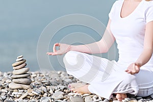 Hand of woman meditating in a yoga pose on beach