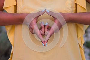 Hand of a woman meditating in a yoga pose on the beach at sunset