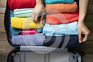 Hand of woman packing a luggage for a new journey and travel for a long weekend