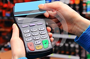 Hand of woman paying with contactless credit card, NFC technology