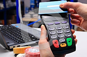 Hand of woman paying with contactless credit card, NFC technology