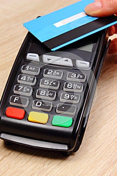 Hand of woman paying with contactless credit card with NFC technology, finance concept