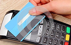 Hand of woman paying with contactless credit card with NFC technology, finance concept