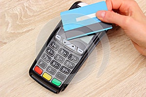 Hand of woman paying with contactless credit card with NFC technology, finance concept