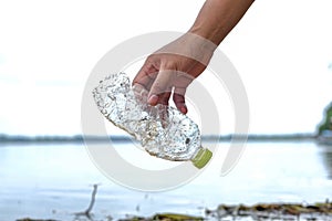 Hand Woman picking up empty plastic bottles cleaning on the beach. volunteer concept, Environmental pollution