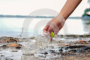 Hand Woman picking up empty plastic bottles cleaning on the beach. volunteer concept, Environmental pollution