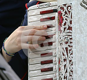 Hand of a woman plays the ancient accordion keyboard