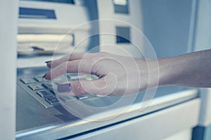 Hand of woman pressing keyboard at local cash machine. Close up