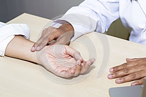 Hand woman professional doctor take the pulse with patient at hospital