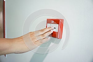 Hand of woman pulling fire alarm switch