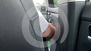 A hand of a woman riding a car as a passenger in taxi on a front seat, travelling by car and long journey concept