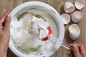 Hand of woman showing the whisked egg whites