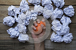 Hand of a woman squeezing a stress ball with crumpled paper