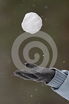 Hand of a woman throw up a snowball