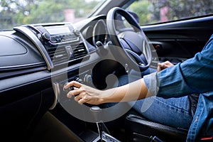 Hand of woman turning on car air condition system, Button on dashboard in car panel, Auto car air condition