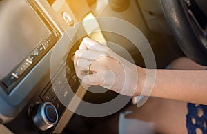 Hand woman turning on car air conditioning system,Finger turns on air button