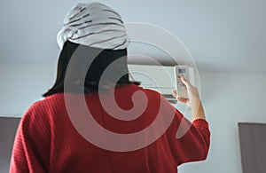 Hand woman using a remote control to activating air conditioning