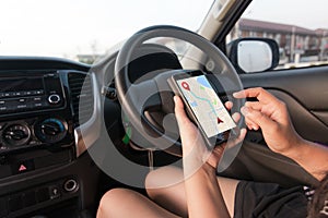 Hand of woman using smartphone with gps navigator map application in SUV car