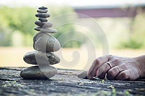 Hand of woman waiting for another stone for balance