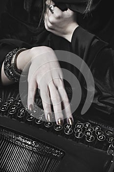 Hand of a woman writing at a typewriter photo