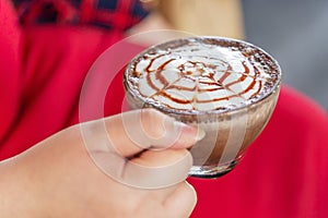 Hand women with cappuccino coffee blurred background