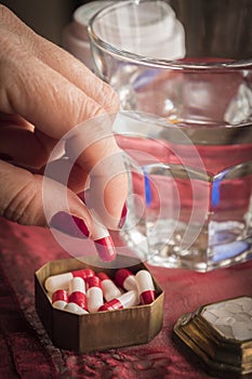 Hand women take capsules red and white