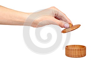 Hand with wooden container, round case. Isolated background