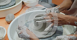 Hand work on pottery wheel, shaping clay pot