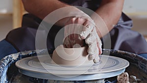 Hand work on pottery wheel, shaping a clay pot, student make of clay pot at studio