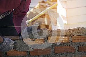 hand of worker installing bricks on construction site