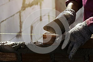 hand of worker installing bricks on construction site