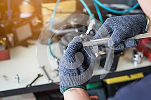 Hand of worker man holding Electric drilling machine on wooden with Drill Press machine . selective focus