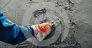 hand of worker plastering cement at wall for building house