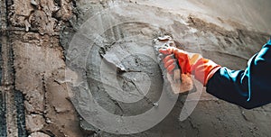 hand of worker plastering cement at wall for building house