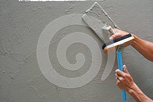 hand of worker plastering cement wall at construction site with copy space