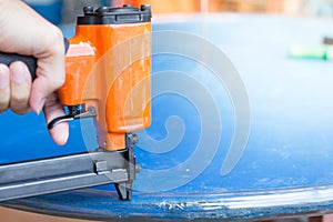 Hand of a worker is using a nail gun