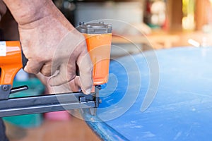 Hand of a worker is using a nail gun