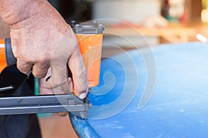 Hand of a worker is using a nail gun