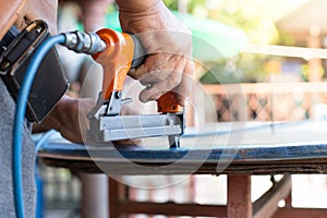 Hand of a worker is using a nail gun