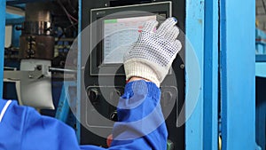 Hand in a working glove clicks on the control panel