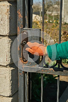 A hand in a working glove opens a door