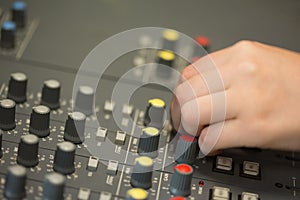 Hand working on a sound mixing desk