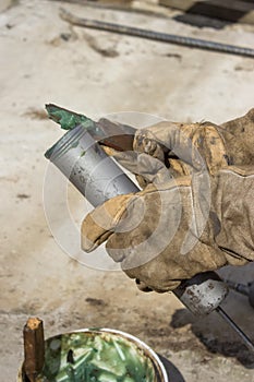 Hand of a workman filling grease gun