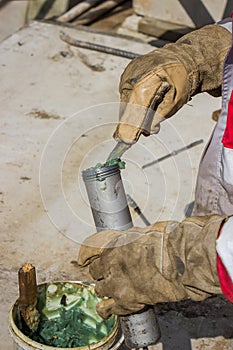 Hand of a workman filling grease gun