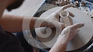 Hand works on pottery wheel, shaping a clay pot, student make of clay pot at studio