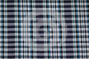 Hand woven traditional cotton fabric in shades of dyed blue and white plaid pattern background